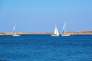 Sailboats on the sea at a rocky coast