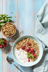 Healthy breakfast cereal bowl homemade granola with fresh raspberry and chia seeds on a rustic table. Diet nutrition concept. View from above. Copy space.