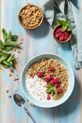 Diet nutrition concept. Healthy breakfast cereal bowl homemade granola with fresh raspberry and chia seeds on a rustic table. View from above.