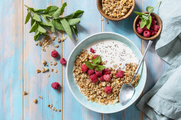 Diet nutrition concept. Healthy breakfast cereal bowl homemade granola with fresh raspberry and chia seeds on a rustic table. View from above. Copy space.