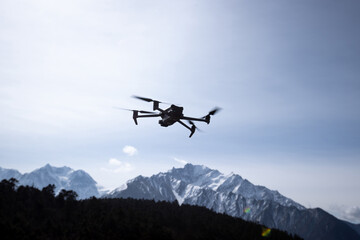 Naklejka na ściany i meble Flying drone in high altitude mountains