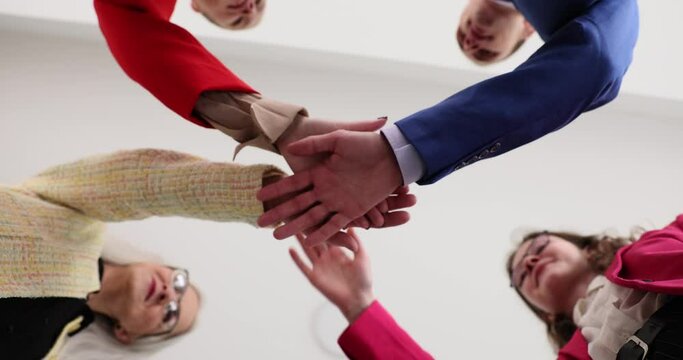 Closeup of many hands clasped together and symbol of team building. Business team loyalty friendship and warm relations between the participants of the seminar