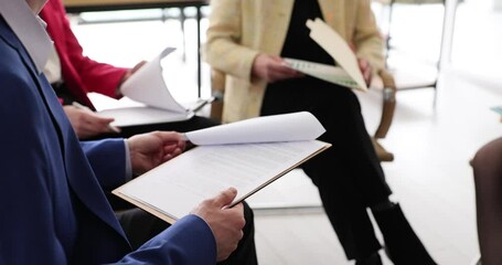 Closeup of statistical data shown on graphs and hands of different businessmen. Discussing the company financial data - Powered by Adobe