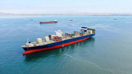Aerial view of blue hull color ultra large container ship in discharged condition at anchor near...