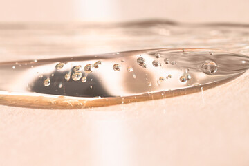 Liquid cosmetic gel on a beige background macro. Means for hygiene, anti-aging, dermatology and skin care concept.