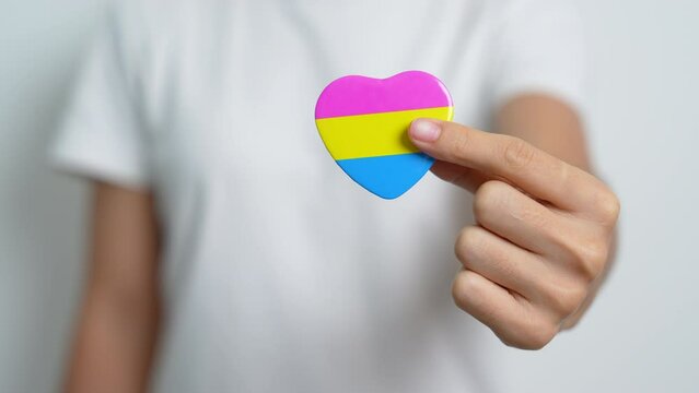 Pansexual Pride Day and LGBT pride month concept. hand holding pink, yellow and blue heart shape for Lesbian, Gay, Bisexual, Transgender, Queer and Pansexual community