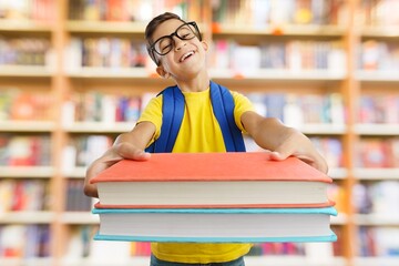 A smart boy hold a book in a school library