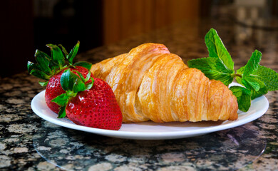 on a plate two delicious appetizing fresh croissants with strawberries and mint beautiful background for postcards congratulations invitations party restaurant menu on billboard background for text