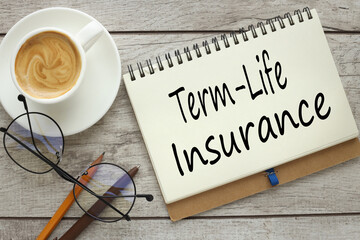 TERM LIFE INSURANCE On a wooden background, a notepad with text with a cup of coffee and glasses