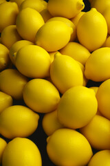 Pile of yellow lemons sitting on top of black counter top. Generative AI.