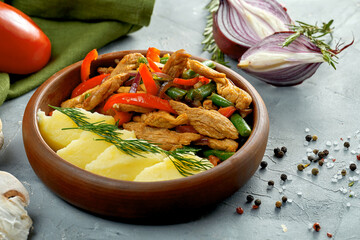 Mashed potatoes and stewed meat with vegetables in a clay bowl. Ukrainian cuisine