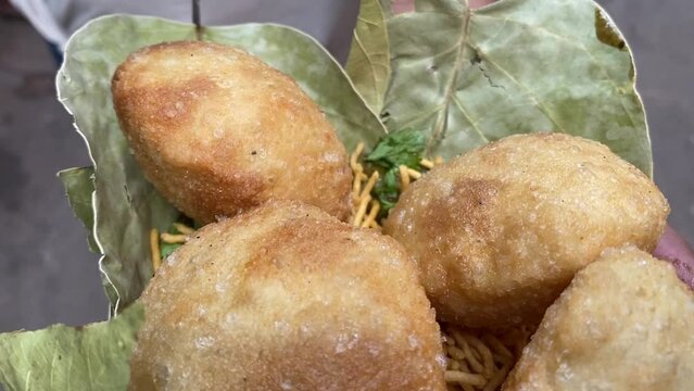 Close up shot of Club Kachori served in Sal leaves plate in road side India.
