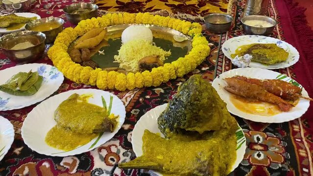 Traditional Bengali dishes for Indian Hindu Durga Puja or pooja festive food. A plate full of khichdi, pulao, curry, payesh and some fries for rice ceremony