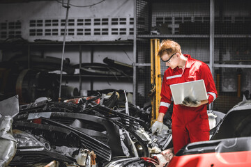 Old used car part warehouse worker checking inventory in garage. Staff worker working in recycle...