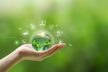 ESG environment social governance concept. Hand-holding crystal globe with ESG icon around...
