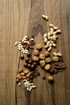 Studio shot of various nuts lying on wooden surface