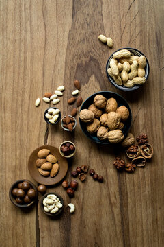 Studio shot of various nuts lying on wooden surface