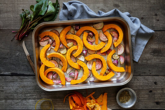 Sliced onions, pumpkins and common beets on baking sheet