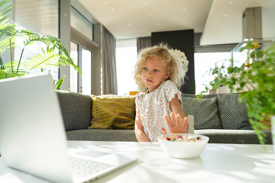 Girl refusing meal watching laptop at home