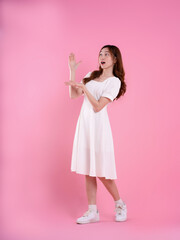 full body image of asian woman in skirt posing on pink background