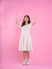 Naklejka premium full body image of asian woman in skirt posing on pink background
