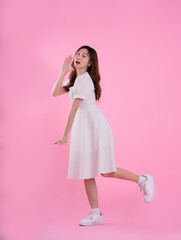 full body image of asian woman in skirt posing on pink background