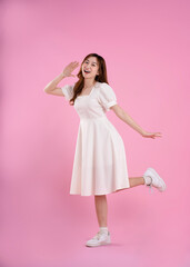 full body image of asian woman in skirt posing on pink background