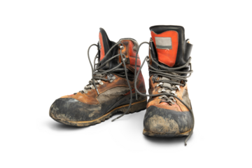 A pair of well worn old leather hiking boots used to protect your feet when walking in the mountains isolated against a transparent background.