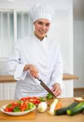 Female chef preparing vegetable salad, cutting vegetables