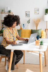 Smiling black woman working on laptop