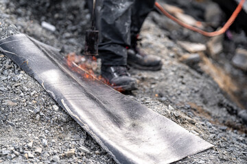 asphalt insulation of buildings. waterproofing, application of help to warm with fire