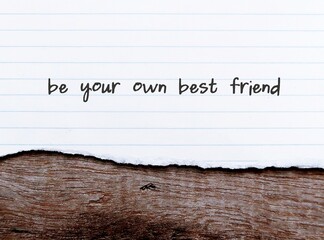 Torn paper on wood background with handwritten text  BE YOUR OWN BEST FRIEND, to make peace and be...