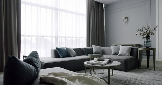 Modern contemporary living room with gray furniture. Modern House Interior With Corner Sofa round table. Fashionable furniture. Minimalist Home Interior. Cozy Modern Furniture. Luxury Elegant Room