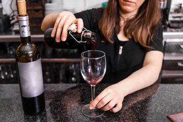 Waitress serving wine in a glass