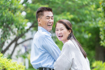 公園を散歩するシニア夫婦