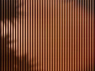 Acoustic fluted wood panel. Plant leaf shadow falling onto panel.
