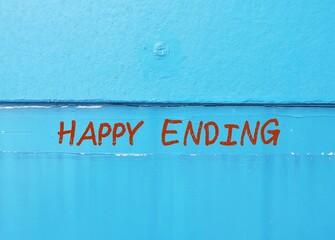 Blue wall with handwriting text HAPPY ENDING - means ending of story or or events in which the people involved are all happy - when all problems are solved