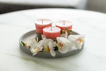 Decorative candles on a concrete base on a marble table in a room. Modern interior in the living room. Close-up. Photo