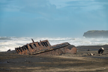 Fascinating ship wrecks on the stormy black sand beaches of the Cook Strait, North Island, New Zealand