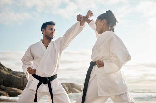Every move has a counter. Cropped shot of two young martial artists practicing karate on the beach.