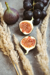 Gold autumn. Croissant, dark grapes, book and figs on the grey table