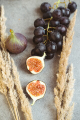 Gold autumn. Croissant, dark grapes, book and figs on the grey table