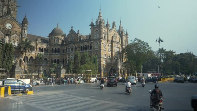 Traffic across streets of Chhatrapati Shivaji Maharaj Terminus station with the view of iconic building at background, Mumbai, India