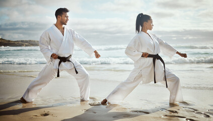 You lead, Ill follow. Full length shot of two young martial artists practicing karate on the beach. © Siphosethu Fanti/peopleimages.com