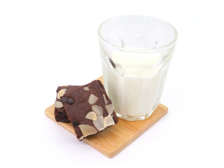 Brownies and milk glass on isolated white background. Chocolate brownie with sliced almond nuts toppings. Chocolate Brownie pieces. selective focus.