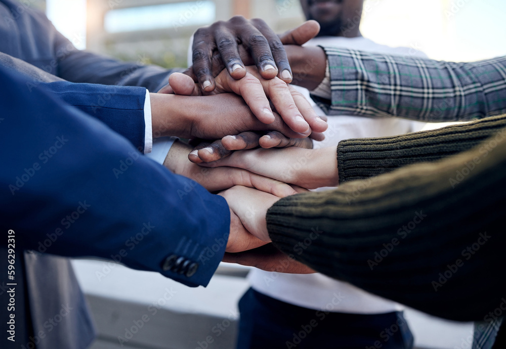 Poster we support each other. shot of a group of unrecognizable businesspeople stacking their hands outside