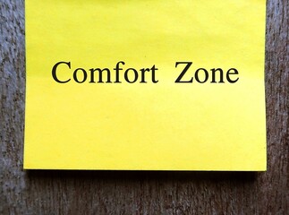 Yellow note on copy space gray wall with text handwritten COMFORT ZONE , concept of psychological state to feel at ease and in control, low anxiety and stress, feel safety