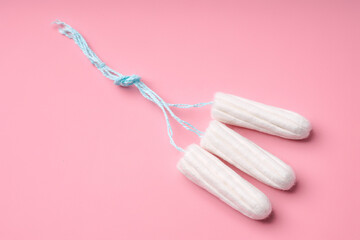 Medical female tampon on a pink background. Hygienic white tampon for women. Cotton swab....