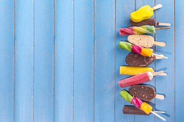 Various ice cream popsicle on high-colored yellow background, summer sweets, dessert, vacation and...