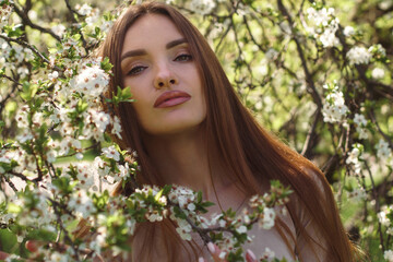 beautiful girl posing in cherry blossom garden